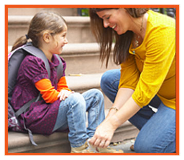 Women tying girl's shoe