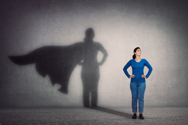 woman with hands on hips and shadow showing a heros cape