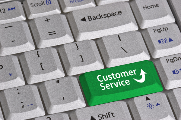 computer keyboard with green key labeled customer service