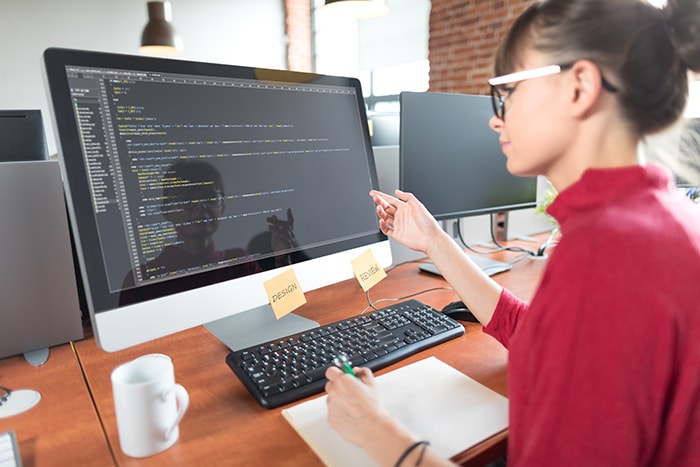 female working in code on desktop