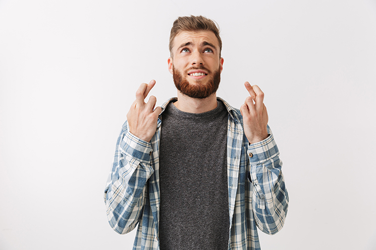 Man crossing fingers hoping for luck