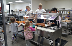 Three football players serving lunch