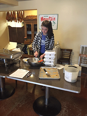 Fiona Raney dishing out a serving of fruit for a customer.