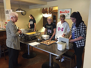 Fiona Raney dishing out a serving of fruit for a customer.