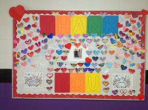 Bulletin board of thank you notes and hearts for Josh and John