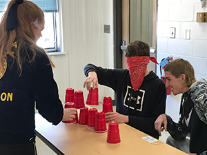 Grace Long participates in an activity with Joe Condon and Chase Miller