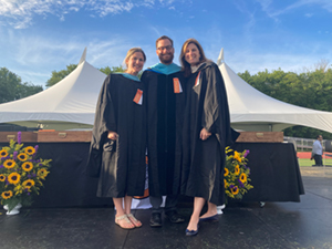 Three teachers in graduation robes