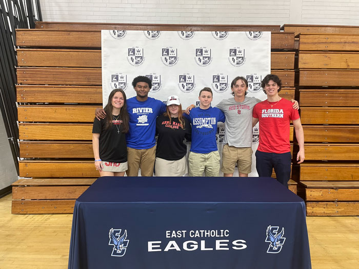 Four students sitting at a college signing table