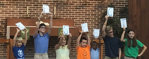 Students holding signs spelling out RESPECT