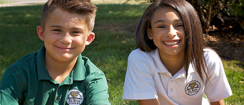 Two smiling students pose outside