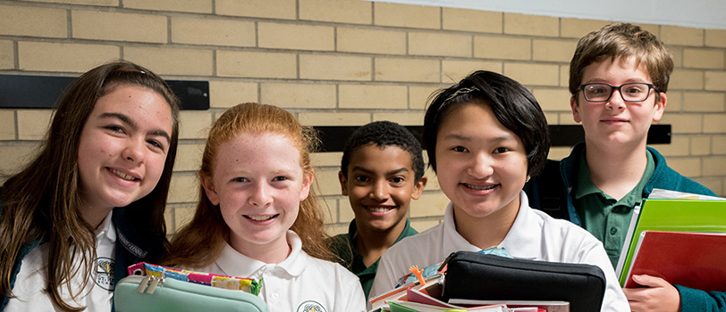 Five smiling students pose together