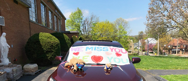 Car with WE MISS YOU poster on top