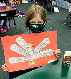 Female student holding turkey art project