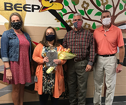 Mrs. Marsha Molina posing next to staff members