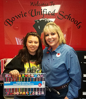Elementary student posing for a picture with a woman in a blue shirt