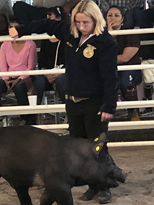 student with her pig at the fair