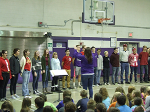 Wide view of Show Cats performing for students with a conductor