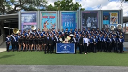 The Paramus High School Spartan marching band pose in front of posters