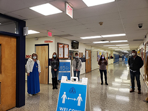 Teachers in hallway social distancing and wearing masks
