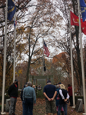 Group of veterans standing in front of memorial