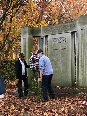 Two veterans standing with memorial