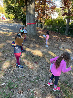 Students walking around outside looking for things on their clipboards