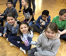 Students pose together on a gym floor