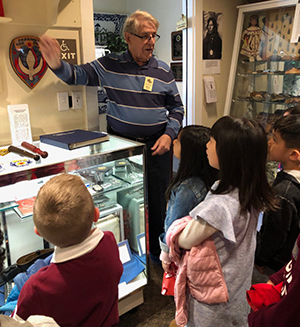 Students participate in the Behnke Museum tour as an adult speaks to them