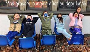 2nd graders lounging after outdoor lunch