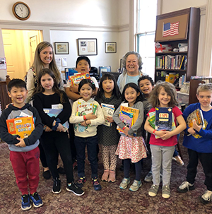 Students pose together in the library with staff members