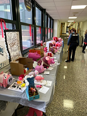 various stuffed animal pigs on a table at the school
