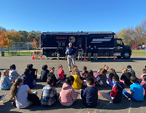 students sitting looking at a bus