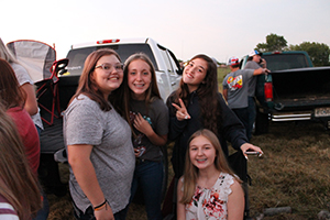 Group of happy students enjoying back-to-school bonfire