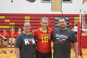 Senior volleyball athlete posing for a picture with her parents