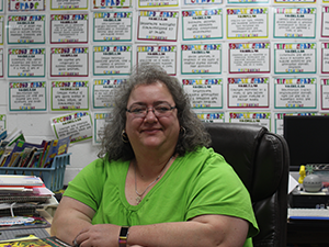 Ms. Grajek poses at her desk