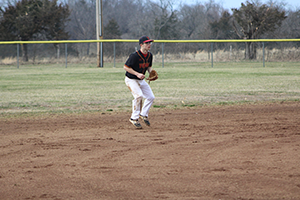 Ethan Matthews on the baseball field holding a baseball glove