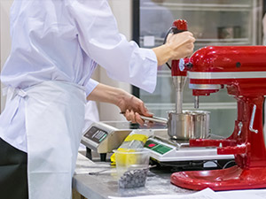 chef with red kitchenaid and weight scales