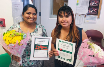 Mable Shaju and Yumara Martinez holding flowers and certificates
