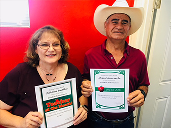 Teacher of the Month Christine Bastidas and Employee of the Month Alvaro Monteverde holding their awards