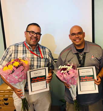 Ralph Lopez and Manny Romero holding flowers and certificates