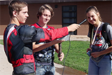Two male students interviewing a female student