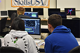 Two students editing film on desktop computer