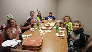 Students eating pizza with the principal