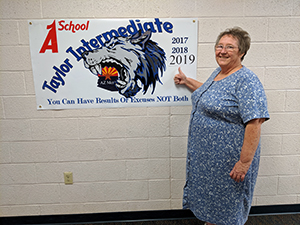 Principal next to sign with A School Taylor Intermediate 2017, 2018, 2019 - You can have results or excuses NOT both