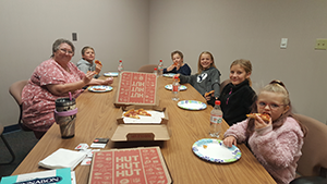 Five students eat pizza with the principal