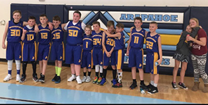 Basketball team poses together in a gym