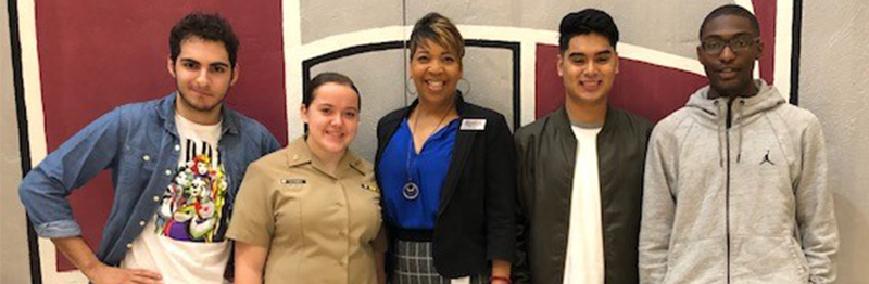 Four students pose with a staff member