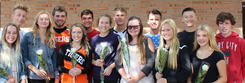 students holding flowers,smiling