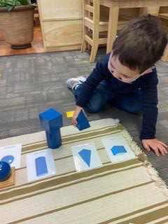 Preschool boy playing with geometric solids