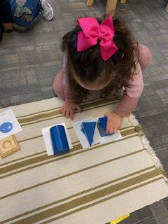 Preschool girl playing with geometric solids